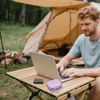 Lavender SSD case beside a portable drive during outdoor laptop use