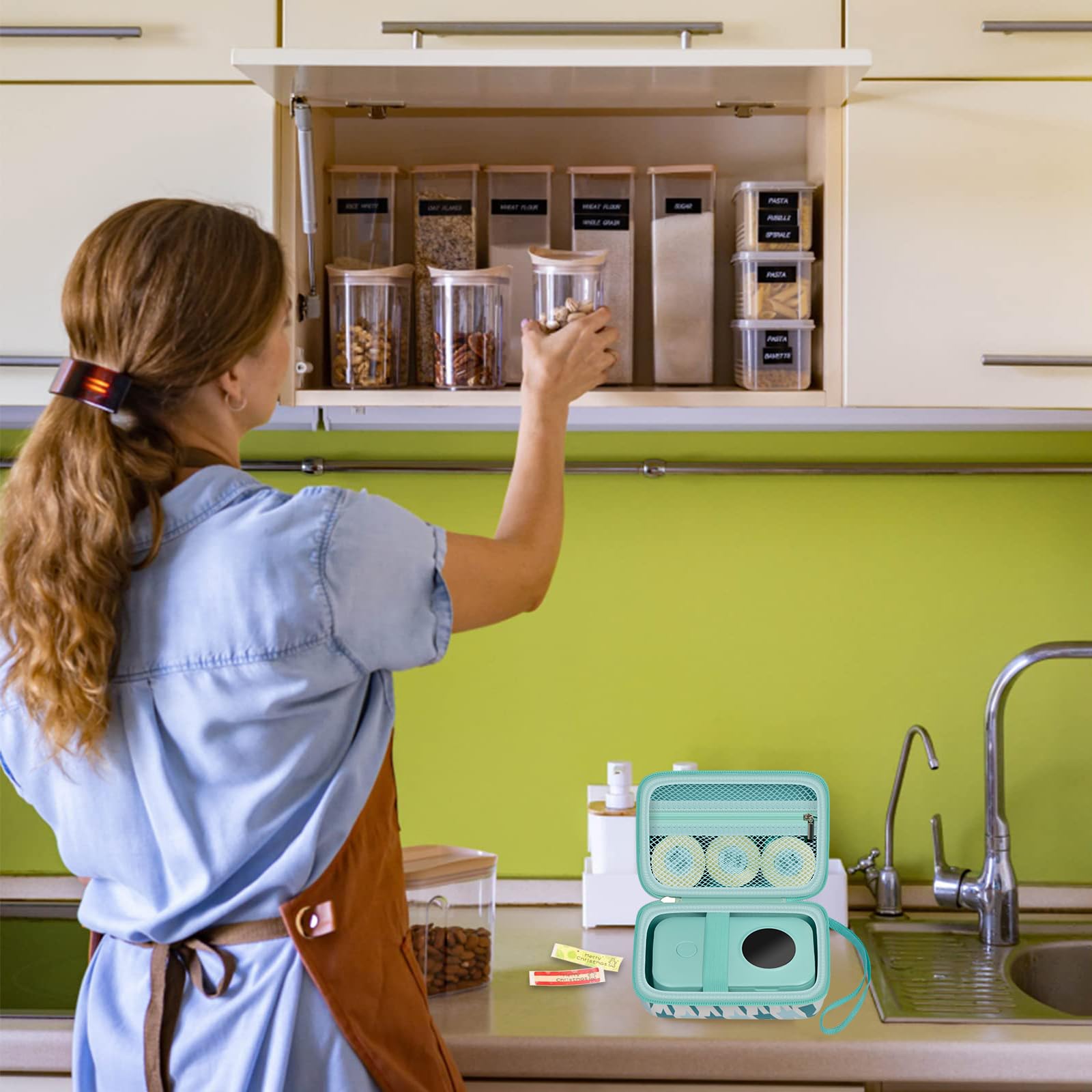 Teal label maker case beside a mini printer in a kitchen organization scene