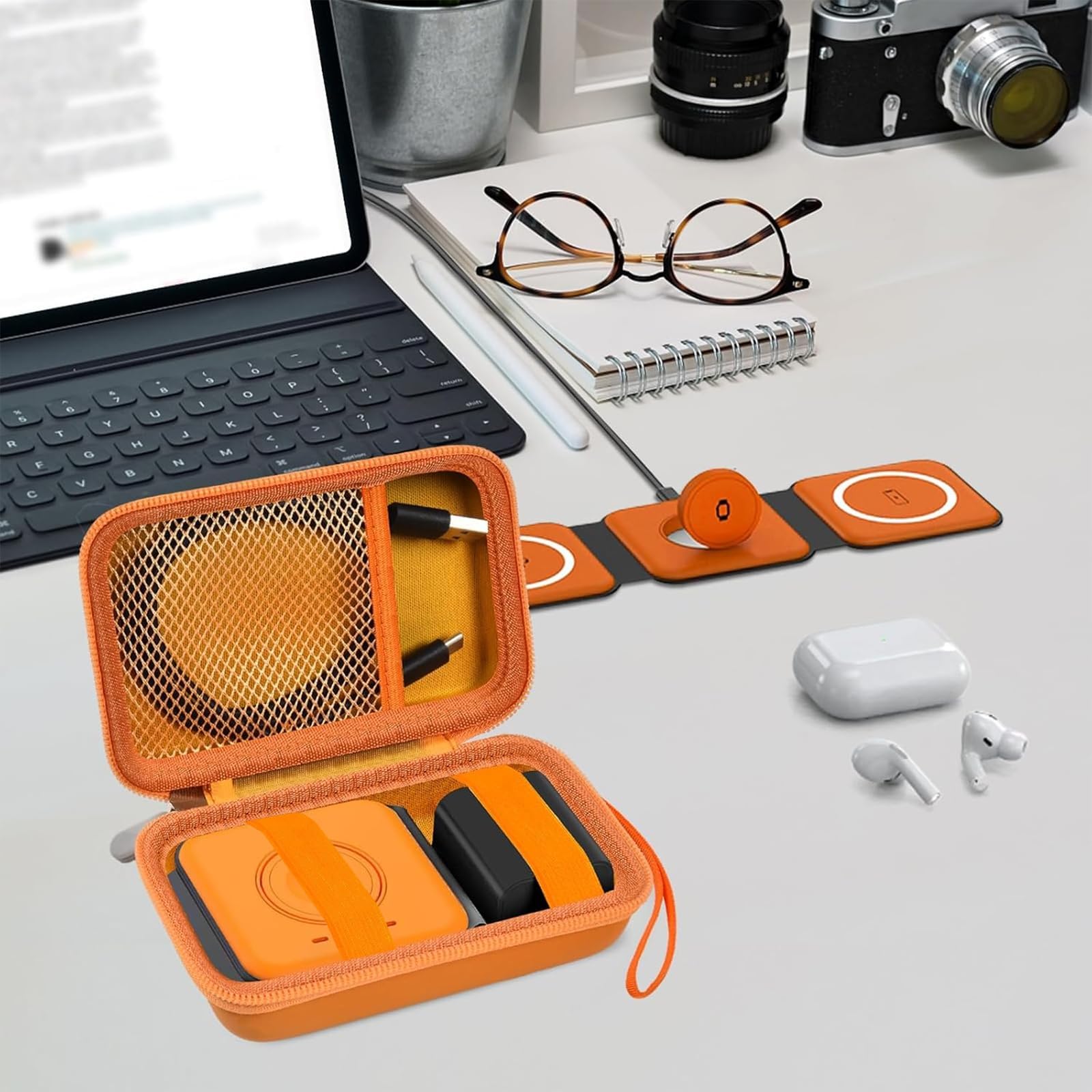 Open orange case organizing a foldable magnetic charger, cable, and adapter on a desk