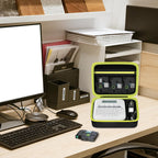 Open black and neon yellow label maker case organizing a printer and tapes on an office desk