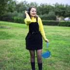 Woman carrying the blue headphone case by its wrist strap