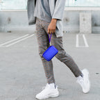 Person carrying the blue charging station case by its wrist strap