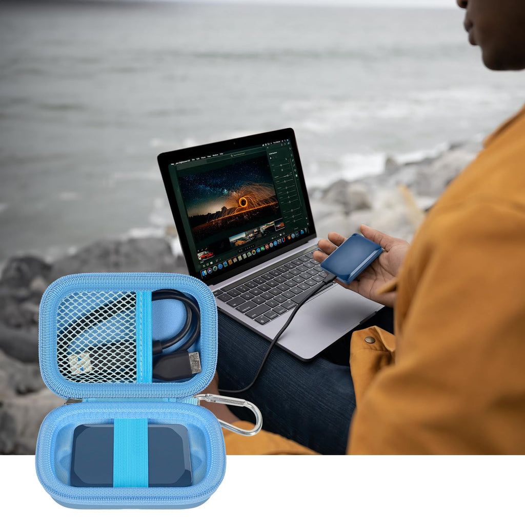 Open blue SSD organizer beside a Crucial portable drive connected to a laptop