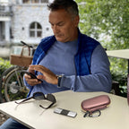 Man using a KardiaMobile device beside the open rose gold travel case
