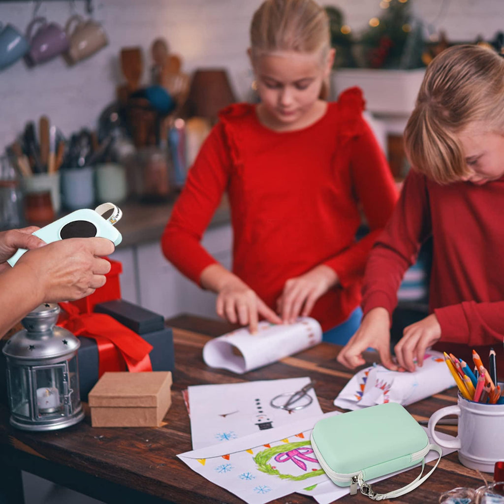Children using a mini label printer beside the mint green carrying case