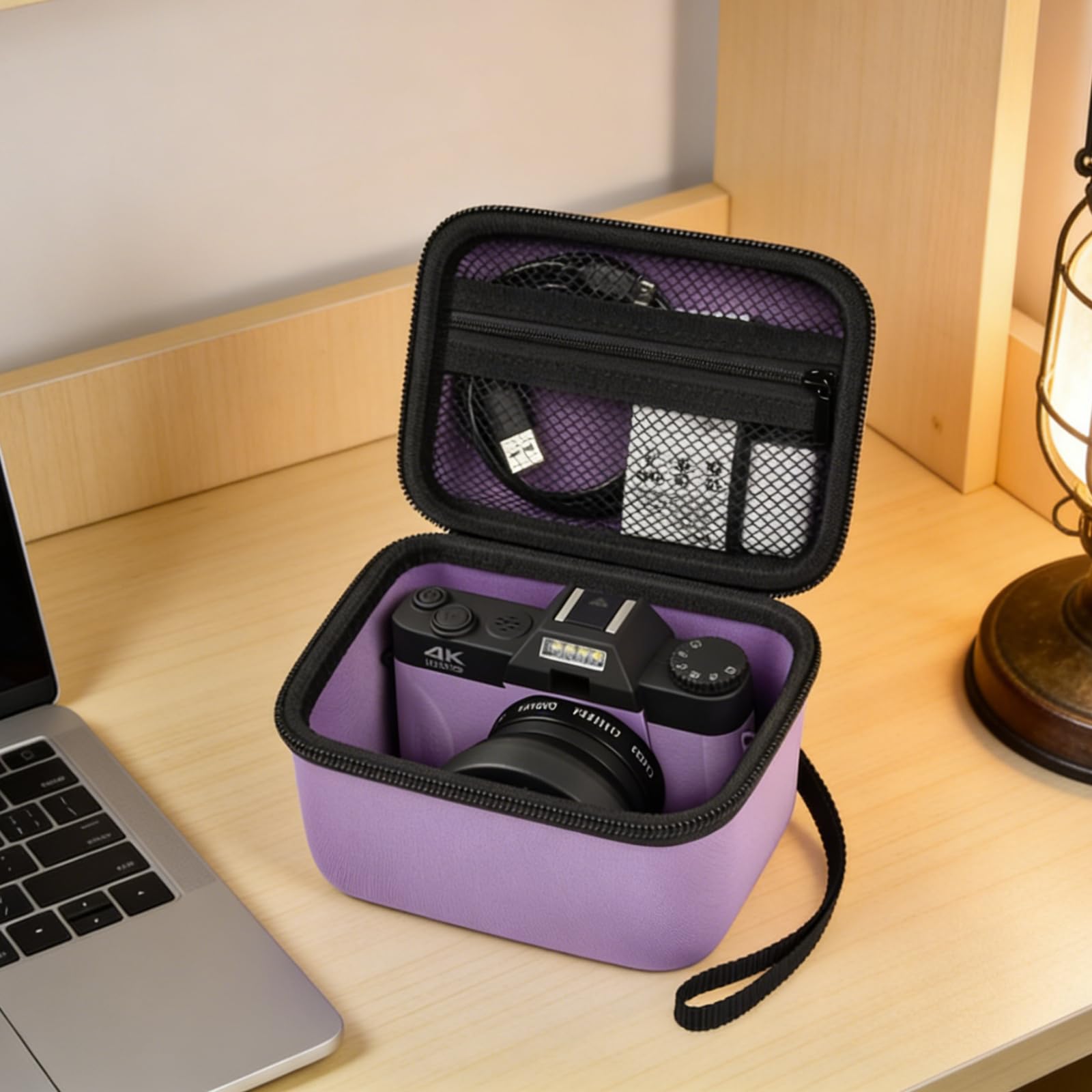 Open purple camera case organizing a camera and accessories beside a laptop