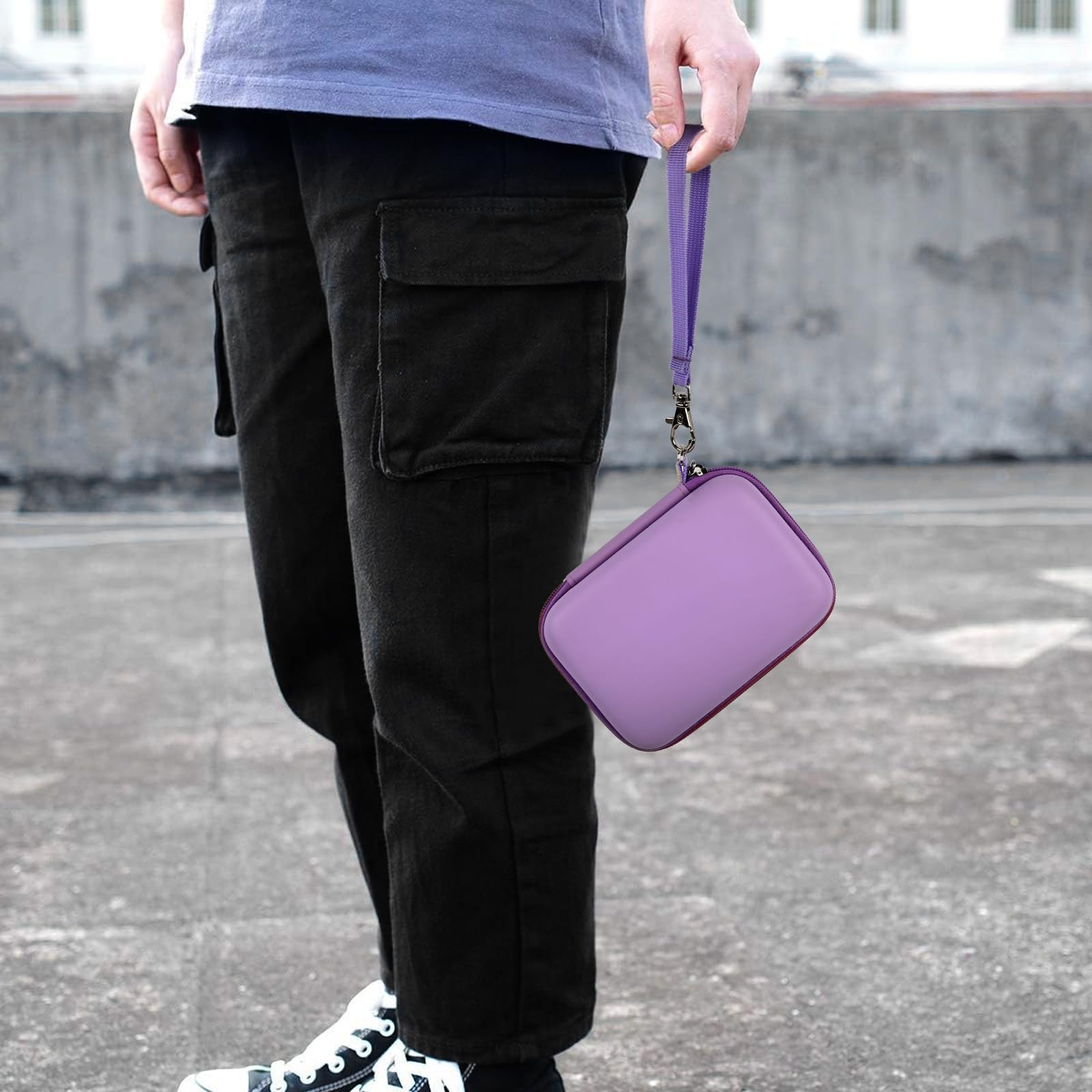Lavender retro handheld console carrying case carried by the wrist strap outdoors