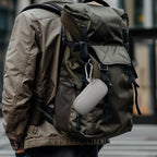 Gray USB flash drive and SD card storage case clipped to a backpack