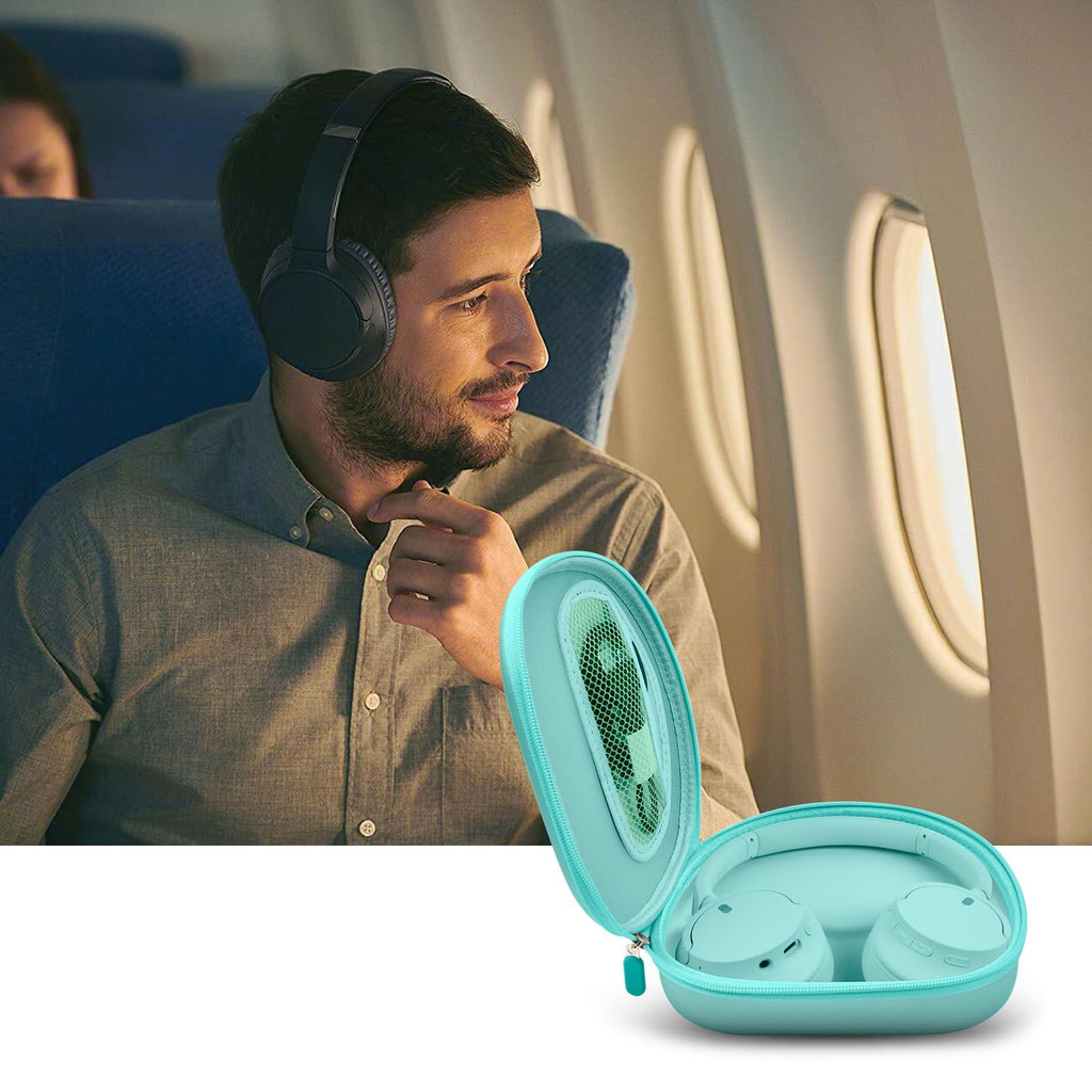 Traveler using headphones beside the open mint green carrying case on an airplane