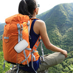 White music player case clipped to a hiking backpack