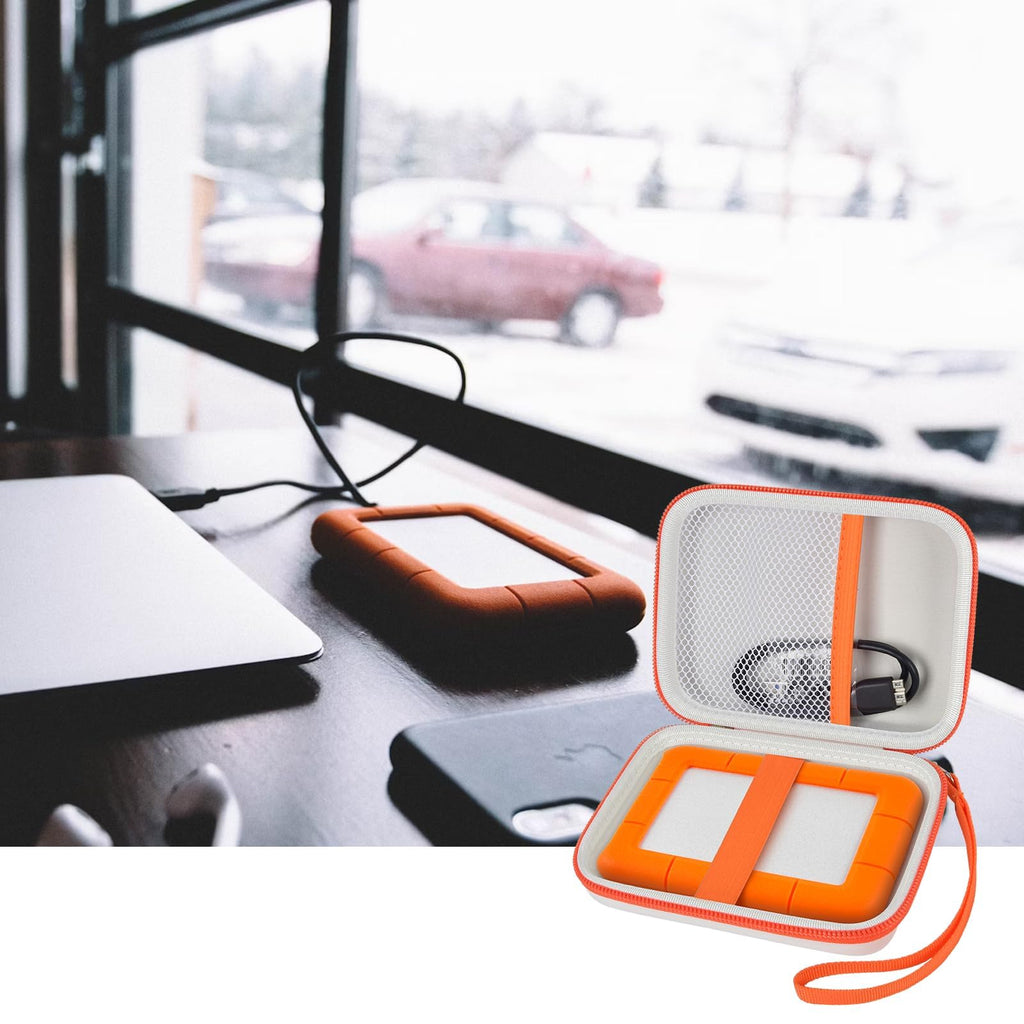 Open gray and orange hard drive case beside a portable drive and desktop computer