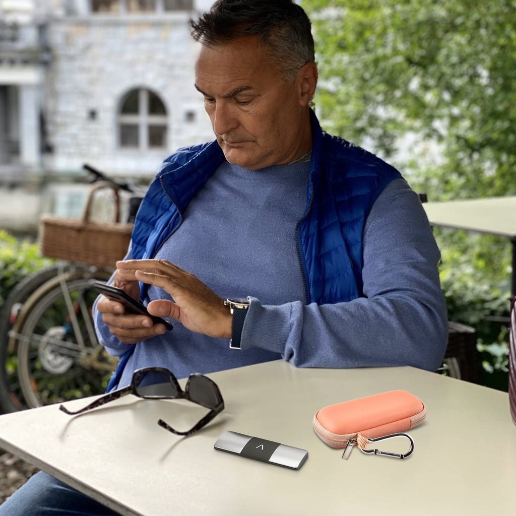Man using a KardiaMobile device beside the open peach travel case