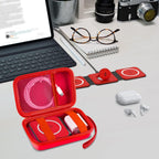 Open red case organizing a foldable magnetic charger, cable, and adapter on a desk