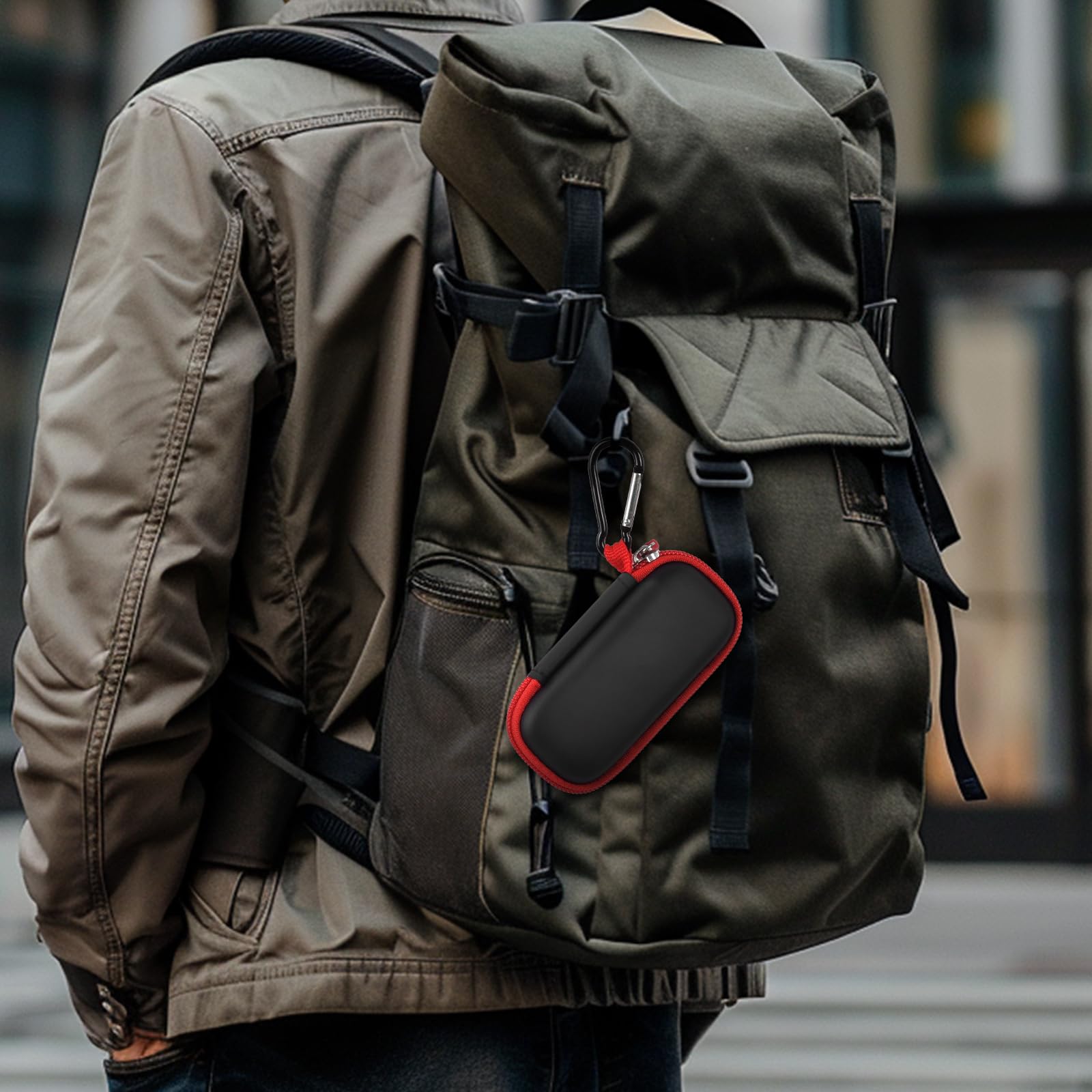 Black and red USB flash drive and SD card storage case clipped to a backpack