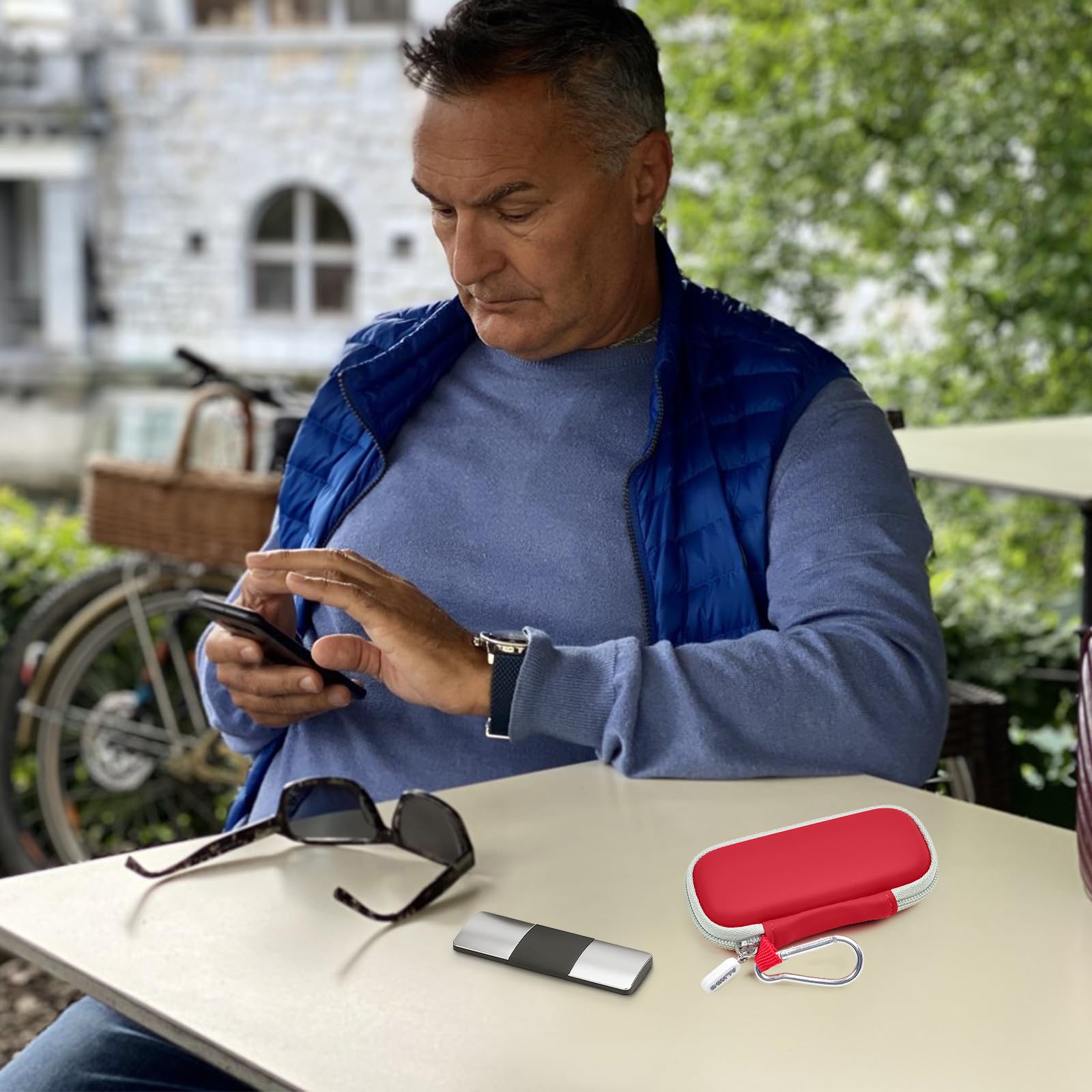 Man using a KardiaMobile device beside the open red travel case