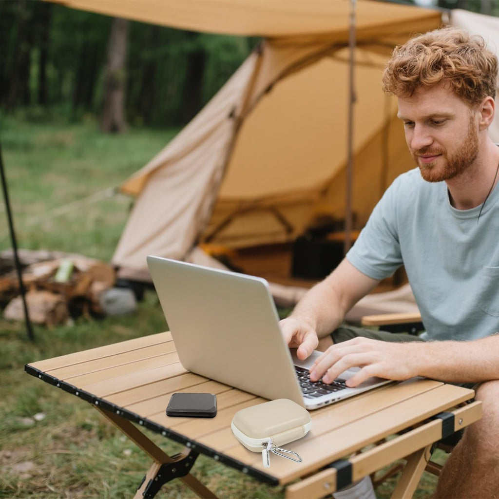Ivory SSD case beside a portable drive during outdoor laptop use