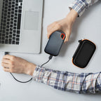Black and orange SSD organizer beside a SanDisk drive connected to a laptop