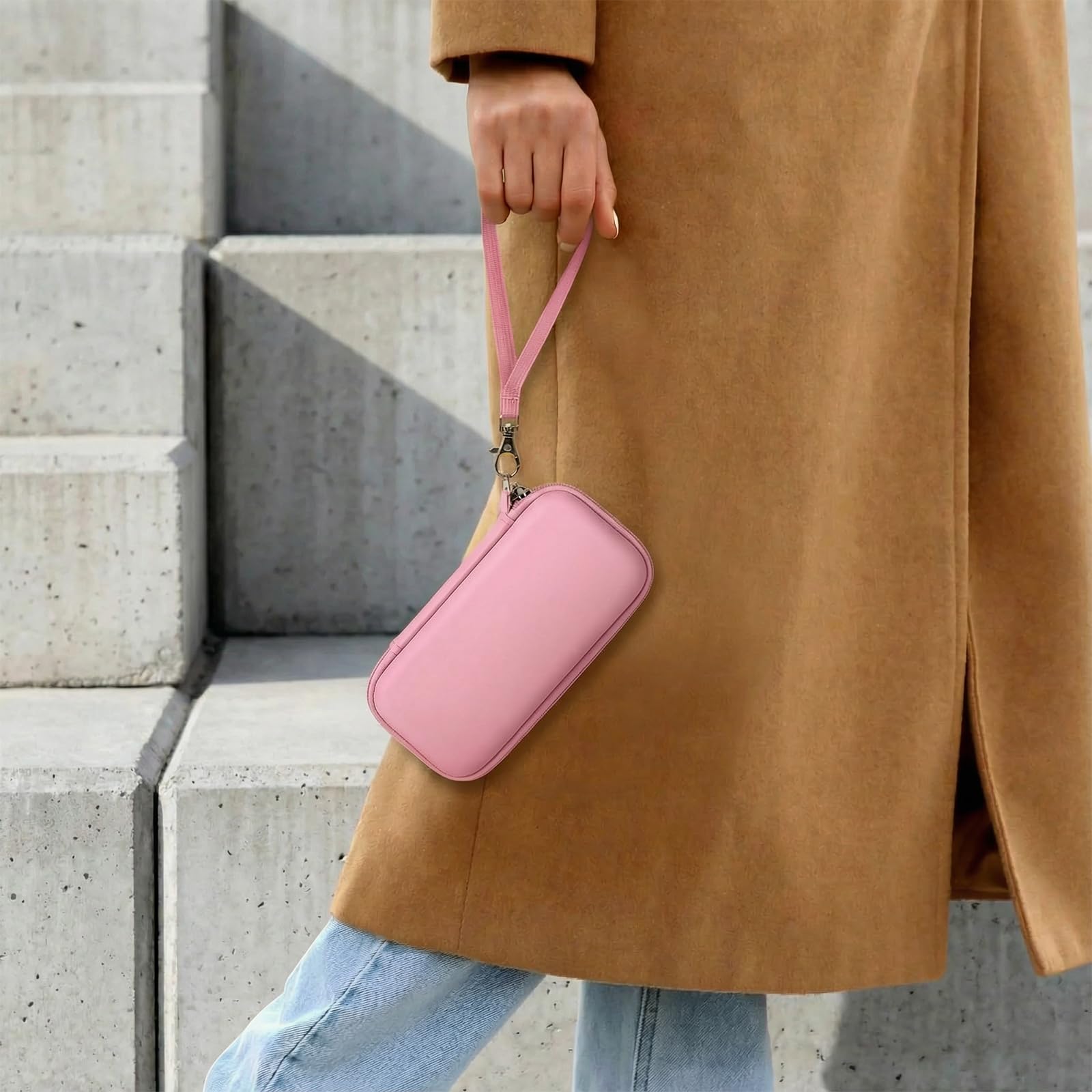 Person carrying the pink power bank case by its wrist strap