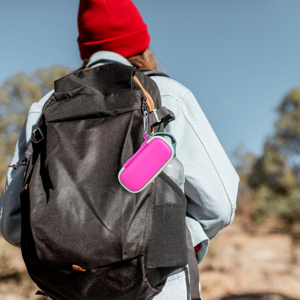Pink KardiaMobile case clipped to a hiking backpack