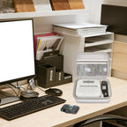 Open gray label maker case organizing a printer and tapes on an office desk