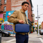 Person carrying the navy microphone case by its top handle
