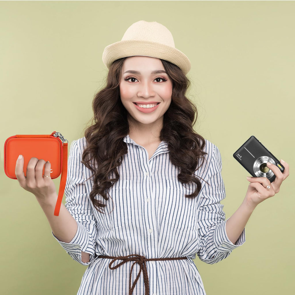 Woman holding the orange camera case beside a compact digital camera