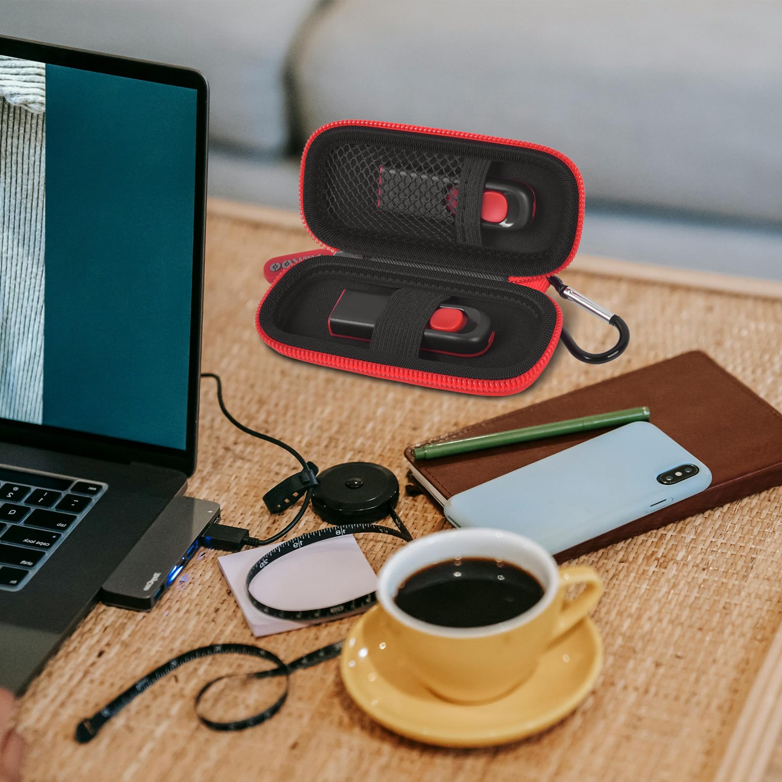 Black and red USB flash drive and SD card storage case open on a desk with electronics accessories