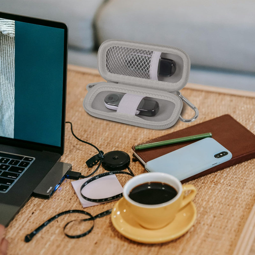 Gray USB flash drive and SD card storage case open on a desk with electronics accessories