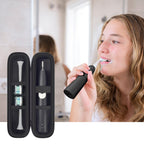 Woman brushing with an electric toothbrush beside the open black travel holder
