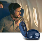 Traveler using headphones beside the open navy blue carrying case on an airplane