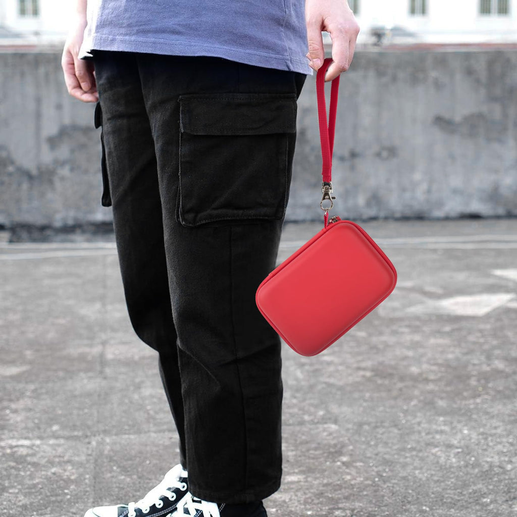 Red retro handheld console carrying case carried by the wrist strap outdoors
