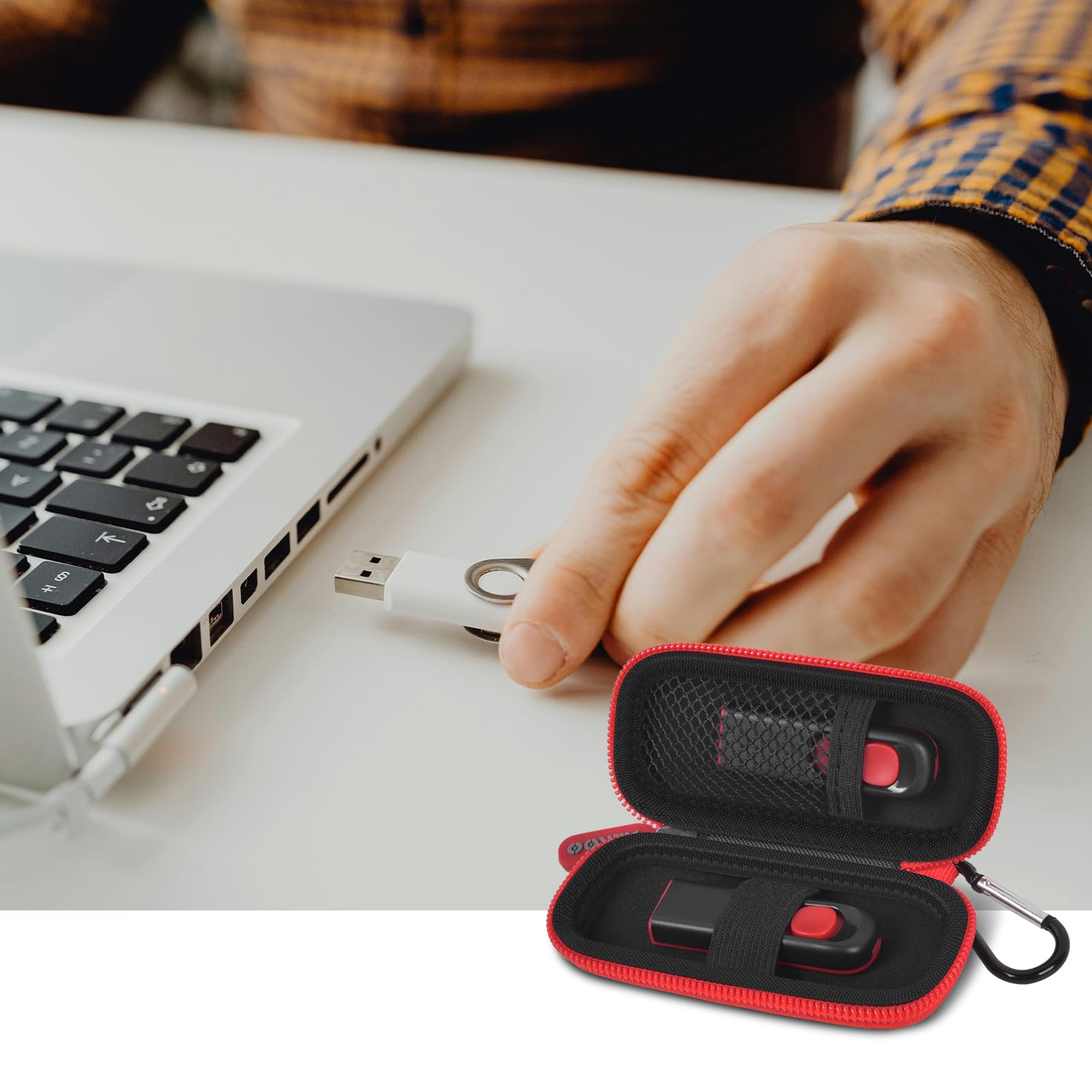 Black and red USB flash drive and SD card storage case open beside a laptop during use