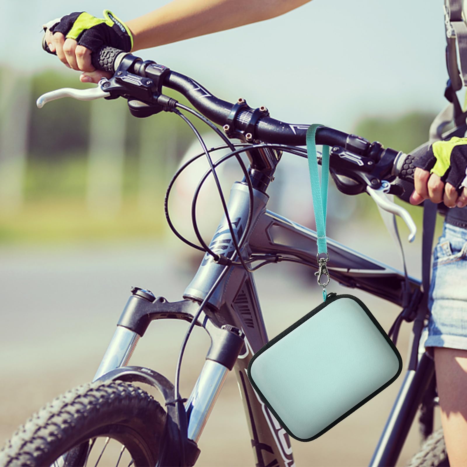 Mint green camera case attached to a bicycle handlebar
