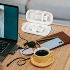 White USB flash drive and SD card storage case open on a desk with electronics accessories