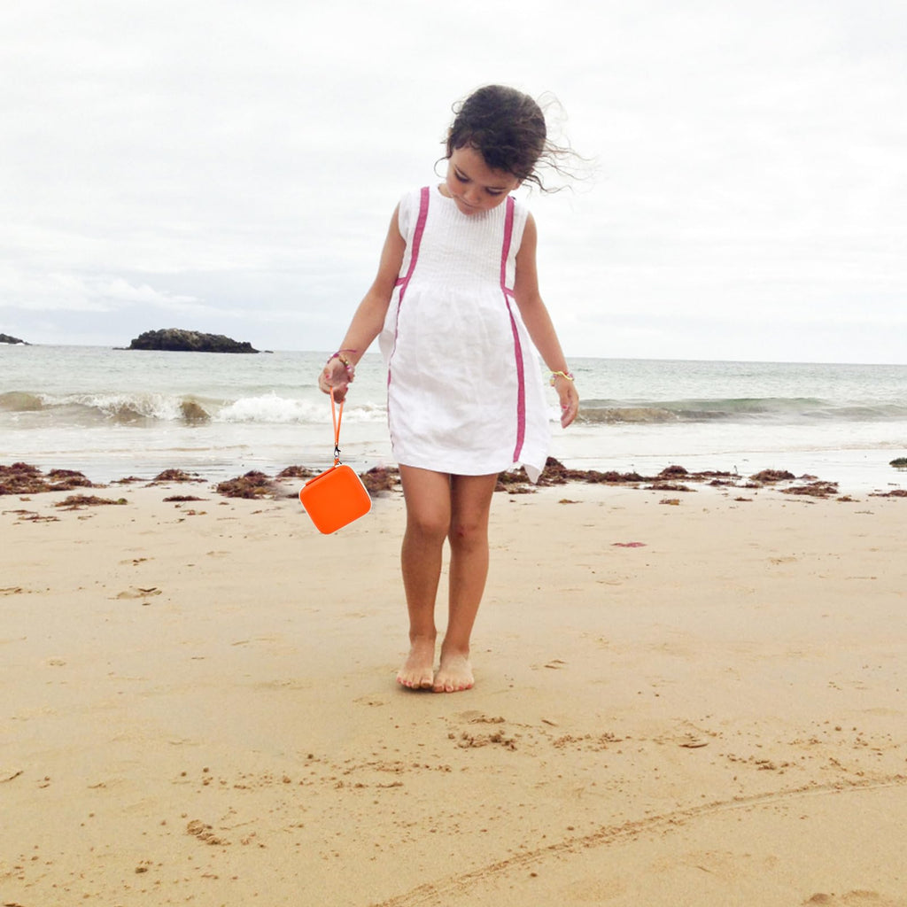 Orange kids instant print camera case carried by a child outdoors