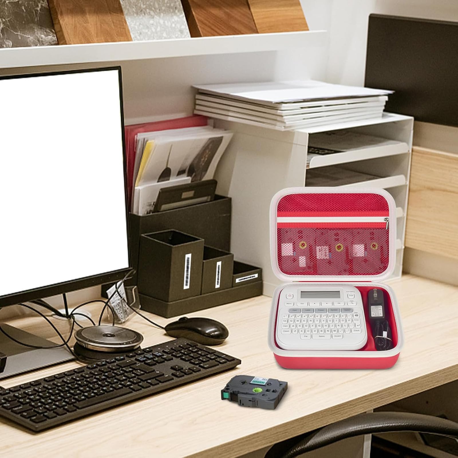 Open red and white label maker case organizing a printer and tapes on an office desk