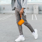 Person carrying the orange charging station case by its wrist strap