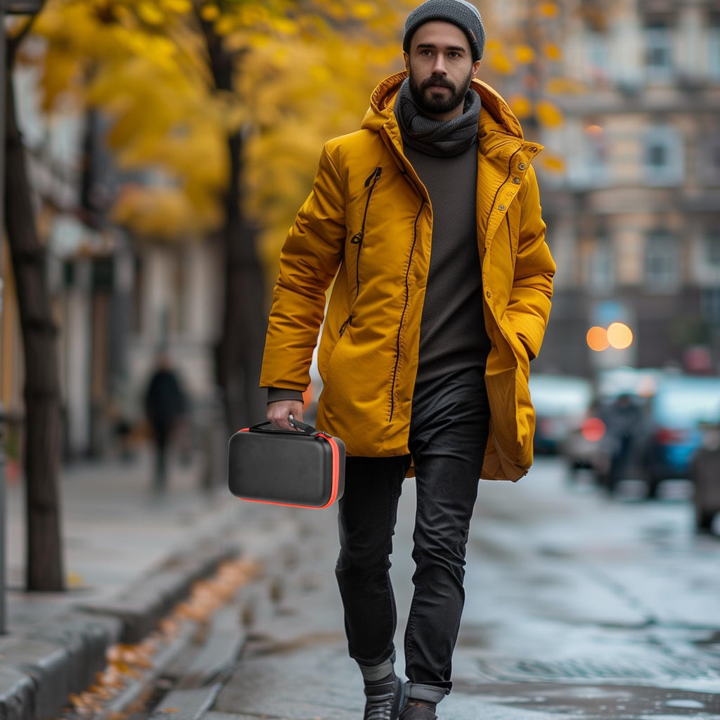Person carrying the black and orange dual microphone case by its top handle