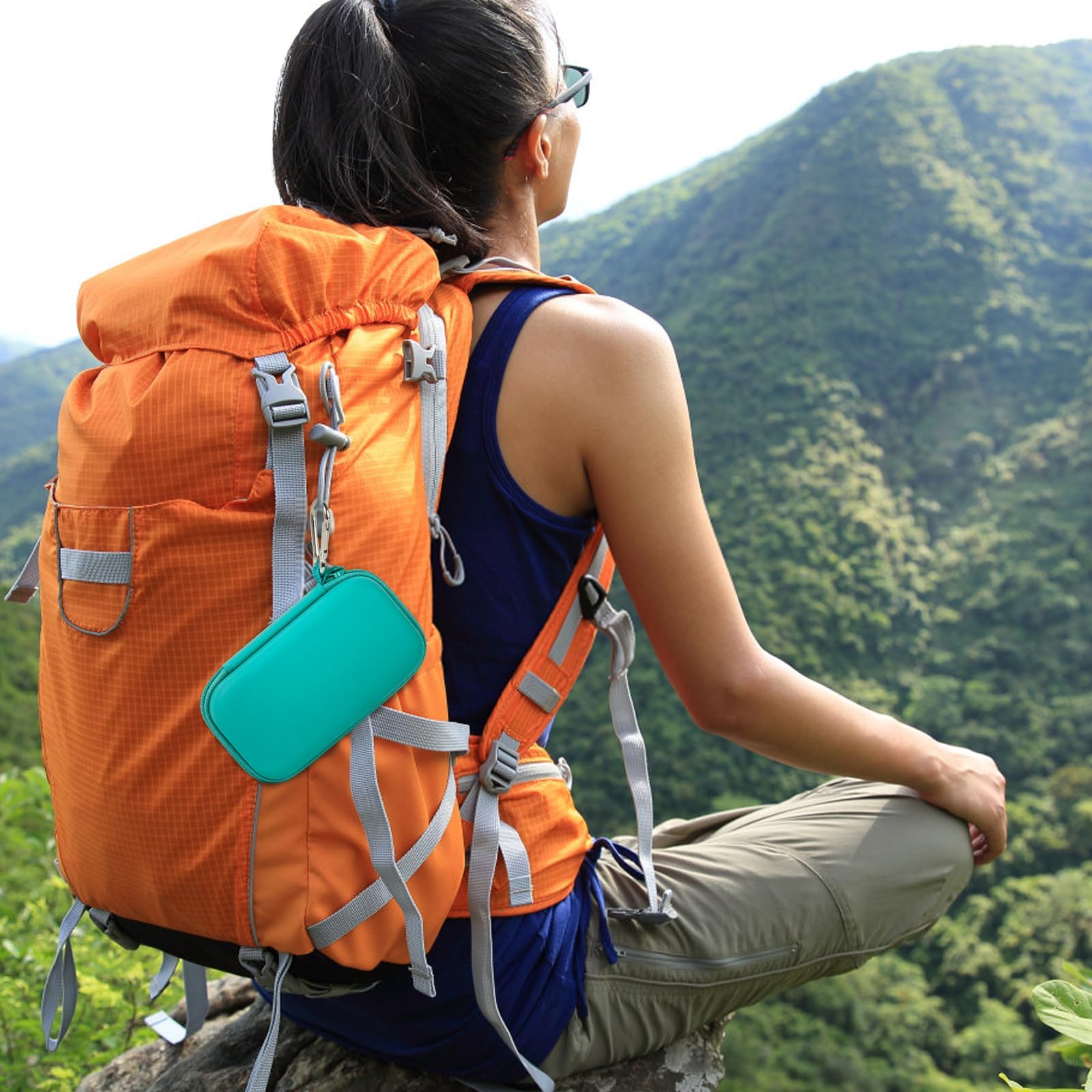 Teal music player case clipped to a hiking backpack