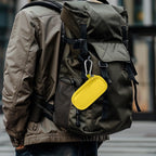 Yellow USB flash drive and SD card storage case clipped to a backpack