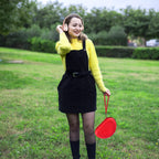 Woman carrying the red headphone case by its wrist strap