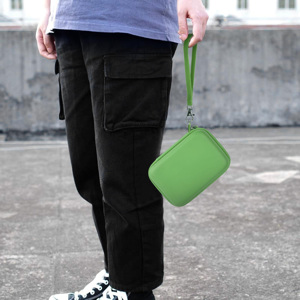 Green retro handheld console carrying case carried by the wrist strap outdoors