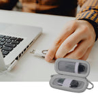 Gray USB flash drive and SD card storage case open beside a laptop during use