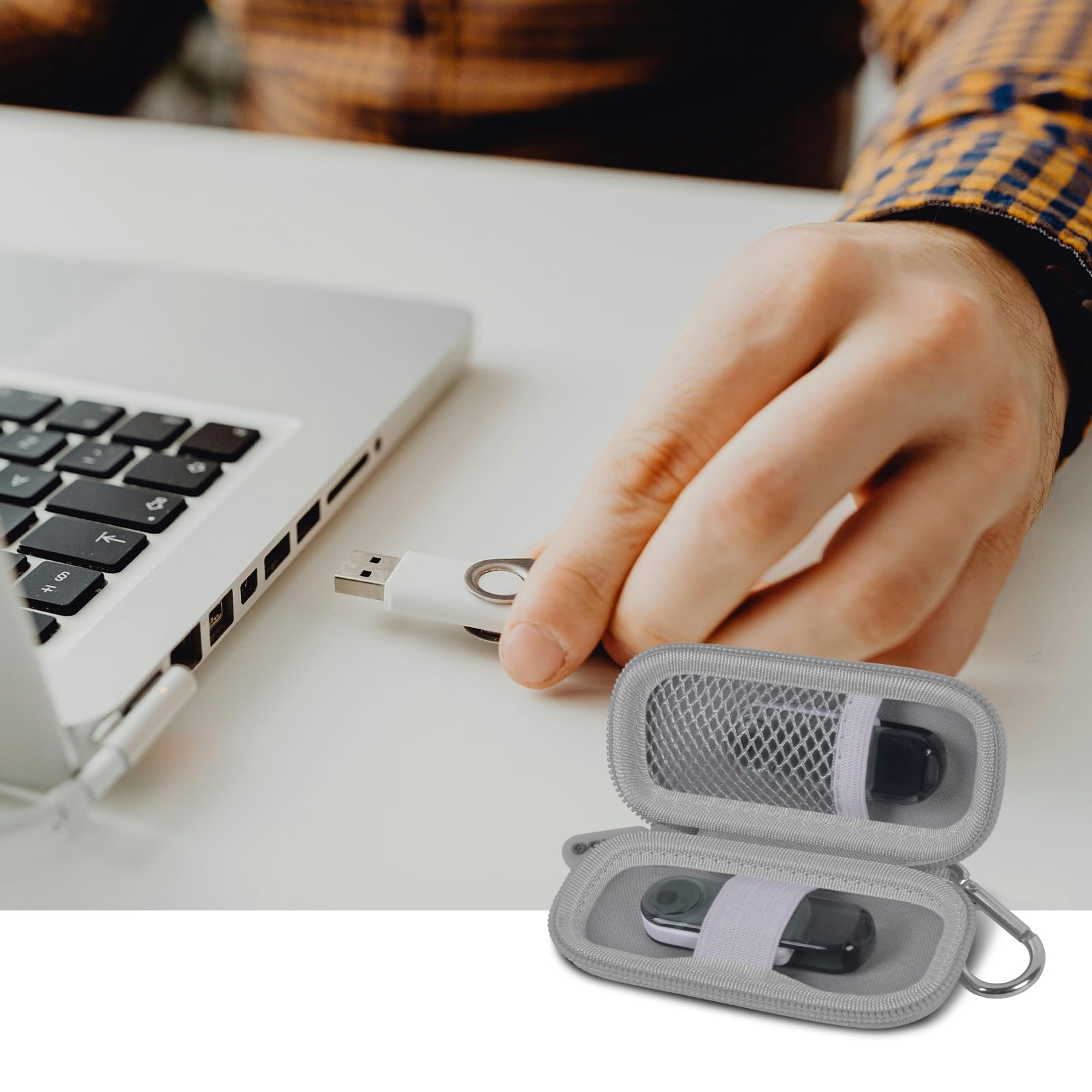 Gray USB flash drive and SD card storage case open beside a laptop during use