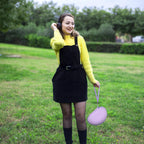 Woman carrying the purple headphone case by its wrist strap