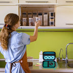 Teal label maker case beside a mini printer in a kitchen organization scene