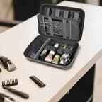 Open gray clipper case organizing clippers, bottles, scissors, combs, and guards on a counter