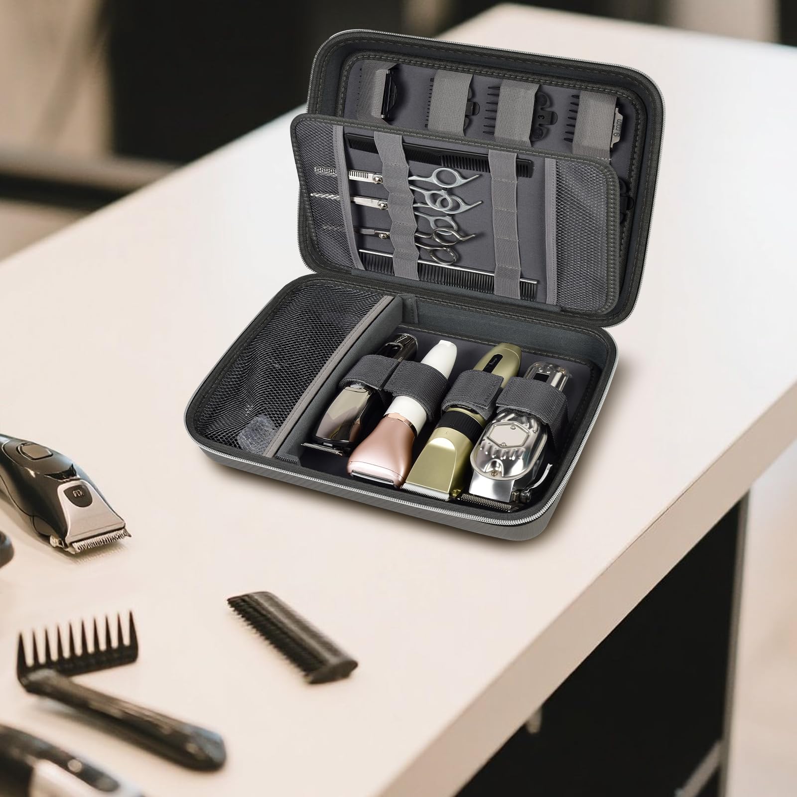 Open gray clipper case organizing clippers, bottles, scissors, combs, and guards on a counter