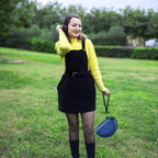 Woman carrying the navy blue headphone case by its wrist strap
