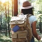 Blue portable SSD case clipped to a hiking backpack